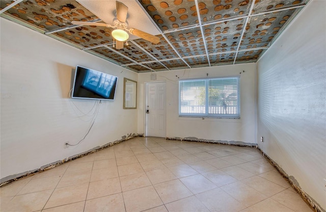 tiled empty room featuring ceiling fan