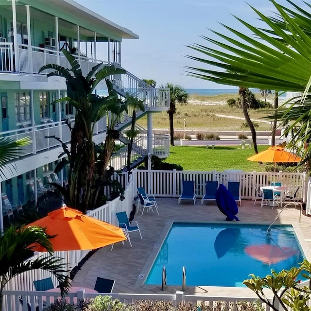 view of swimming pool with a water view and a patio