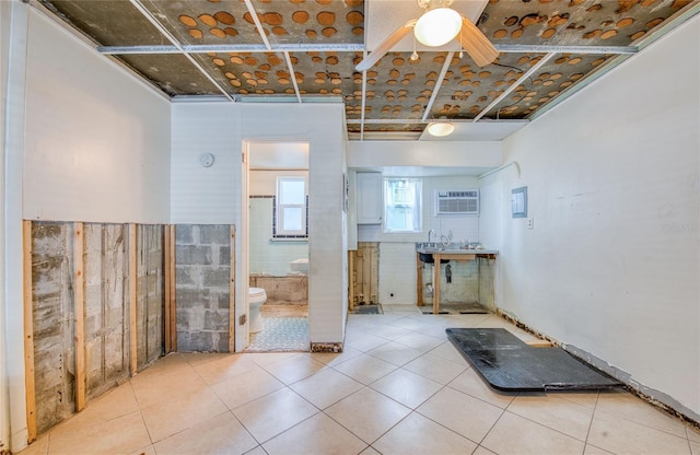 interior space featuring ceiling fan, tile patterned floors, a wall mounted air conditioner, and toilet