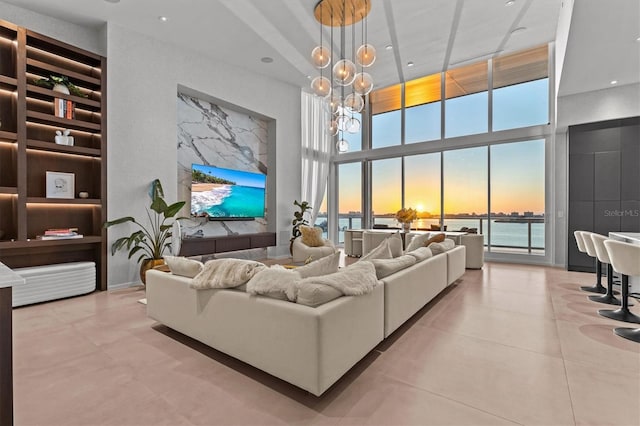 living room featuring a towering ceiling, a chandelier, and light tile patterned floors