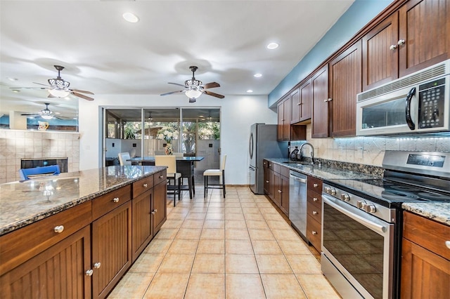 2786 Countryside Blvd Unit 2, Clearwater, FL 33761 - kitchen with light tile patterned flooring, sink, tasteful backsplash, appliances with stainless steel finishes, and dark stone counters