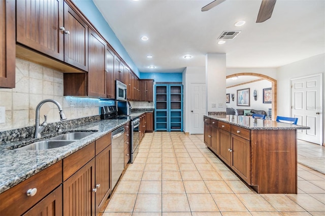 2786 Countryside Blvd Unit 2, Clearwater, FL 33761 - kitchen featuring stone countertops, sink, backsplash, ceiling fan, and stainless steel appliances