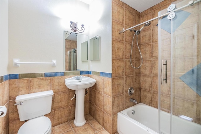 2786 Countryside Blvd Unit 2, Clearwater, FL 33761 - bathroom featuring tile walls, tile patterned floors, combined bath / shower with glass door, and toilet