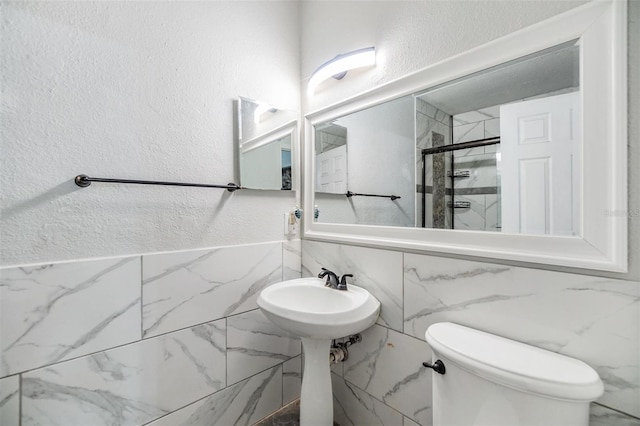 2786 Countryside Blvd Unit 2, Clearwater, FL 33761 - bathroom featuring tile walls, sink, toilet, and walk in shower