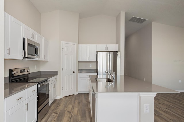 kitchen with sink, stainless steel appliances, white cabinets, a center island with sink, and dark hardwood / wood-style flooring