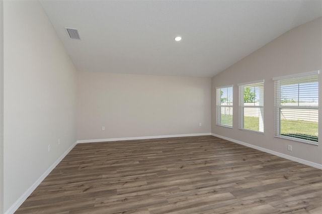 unfurnished room with lofted ceiling and dark wood-type flooring