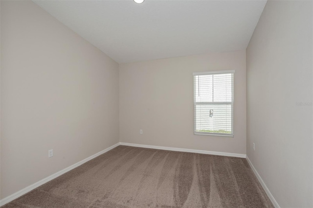 empty room with lofted ceiling and carpet