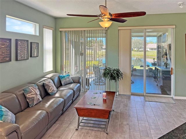living room featuring plenty of natural light, a ceiling fan, and wood finish floors