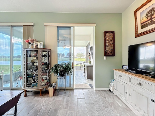 interior space with wood finish floors, baseboards, and ceiling fan