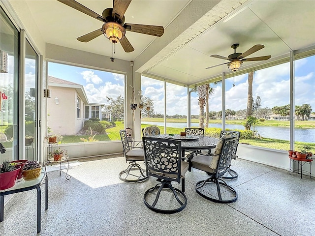 sunroom featuring a water view and ceiling fan