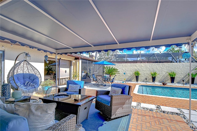 view of patio / terrace with a lanai, a fenced in pool, and an outdoor living space with a fire pit