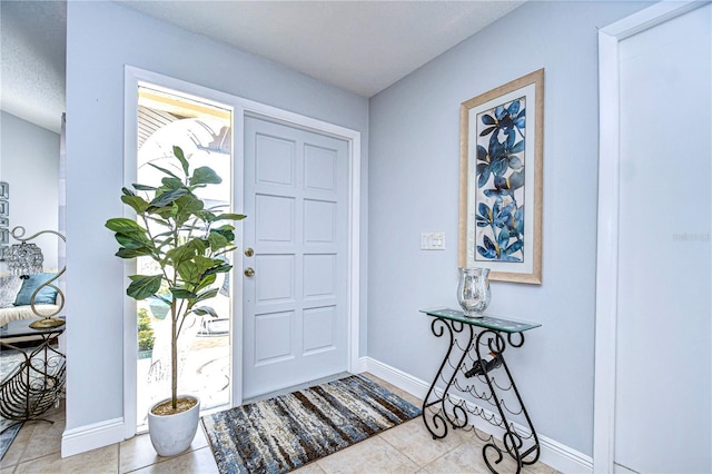 tiled foyer entrance featuring baseboards