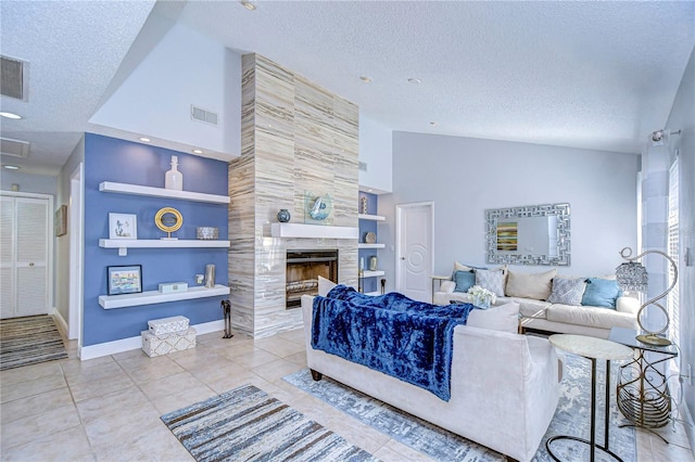 tiled living area with visible vents, built in features, a tiled fireplace, lofted ceiling, and a textured ceiling