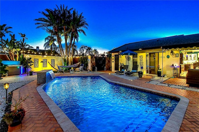 pool with a patio and fence