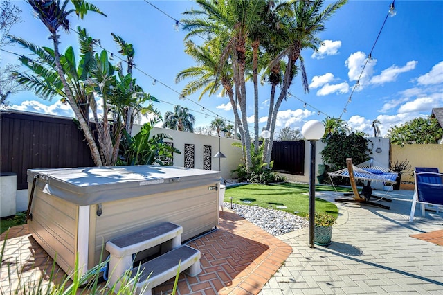 view of patio with a fenced backyard and a hot tub