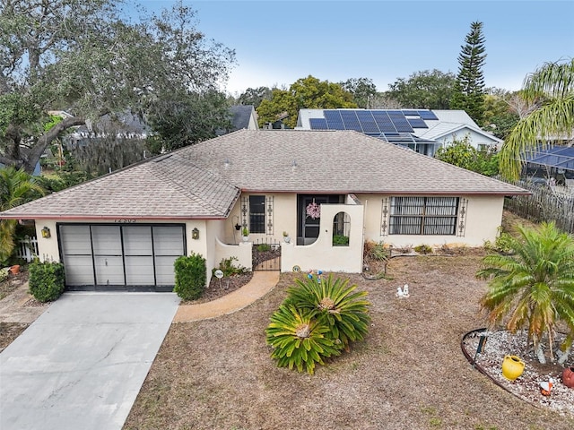 ranch-style home with a shingled roof, driveway, an attached garage, and stucco siding