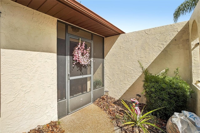 view of exterior entry featuring stucco siding