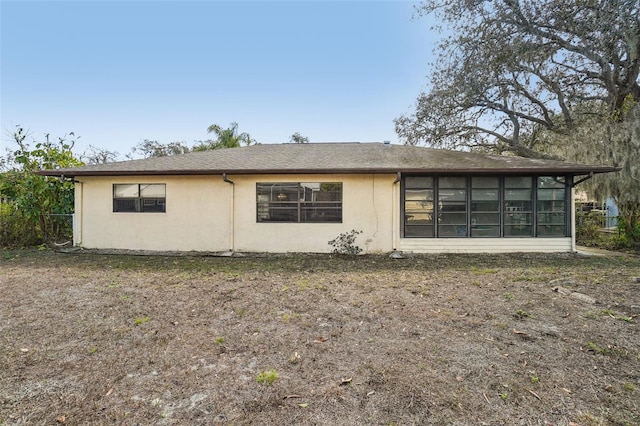 view of side of home with a sunroom and stucco siding