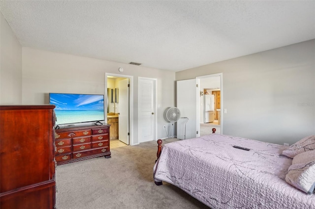 bedroom featuring a textured ceiling, connected bathroom, carpet flooring, visible vents, and freestanding refrigerator