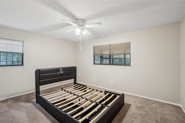 bedroom with carpet flooring, a textured ceiling, and baseboards