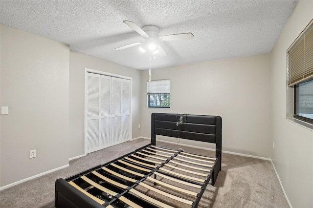 bedroom featuring carpet floors, a closet, ceiling fan, and baseboards