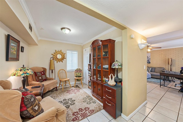 tiled living room featuring crown molding, ceiling fan, and brick wall