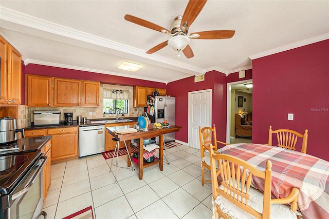 kitchen featuring light tile patterned flooring, stainless steel appliances, crown molding, and decorative backsplash