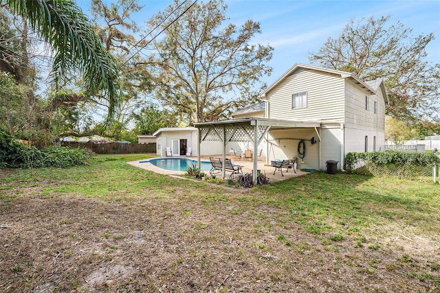 back of house with a fenced in pool, a patio area, and a lawn