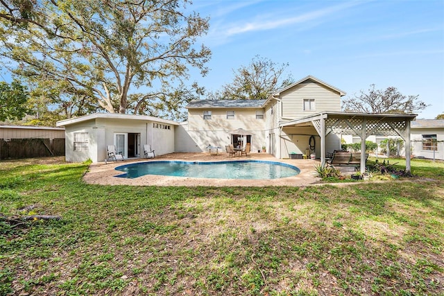 rear view of house featuring a patio area and a lawn