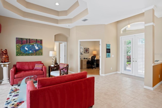 living room with french doors, light tile patterned flooring, a raised ceiling, and baseboards