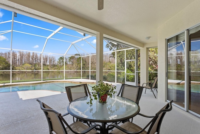 sunroom featuring a water view