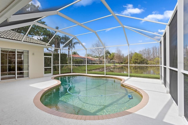 outdoor pool with a patio, a water view, and glass enclosure