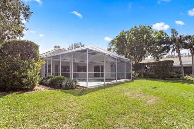 back of property featuring glass enclosure, a lawn, a patio area, and an outdoor pool