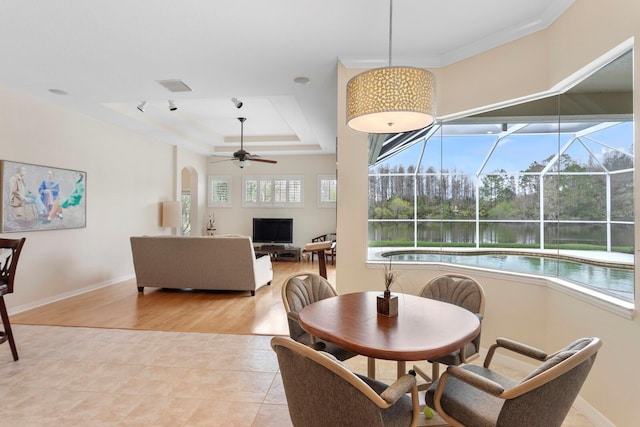 dining area with ceiling fan, a sunroom, visible vents, baseboards, and a raised ceiling