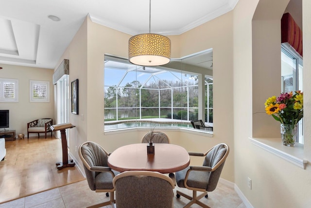 dining space with light tile patterned floors, crown molding, a sunroom, and baseboards