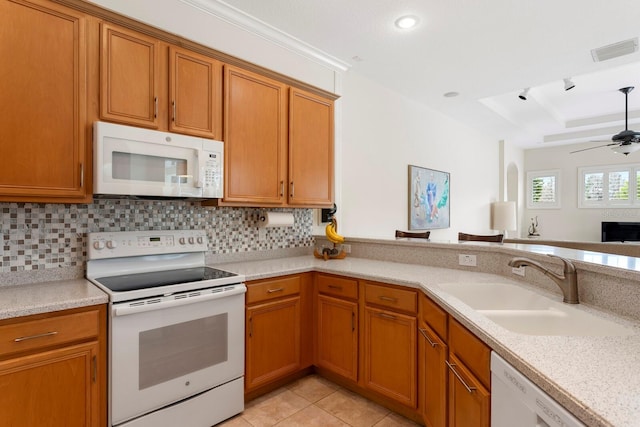 kitchen with a tray ceiling, light tile patterned floors, visible vents, a sink, and white appliances