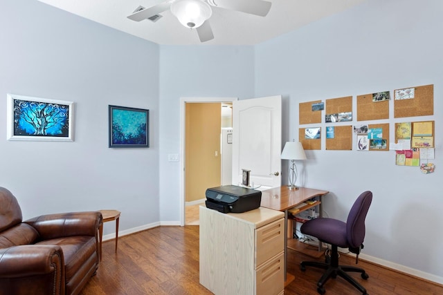 office space with a ceiling fan, baseboards, and dark wood-type flooring