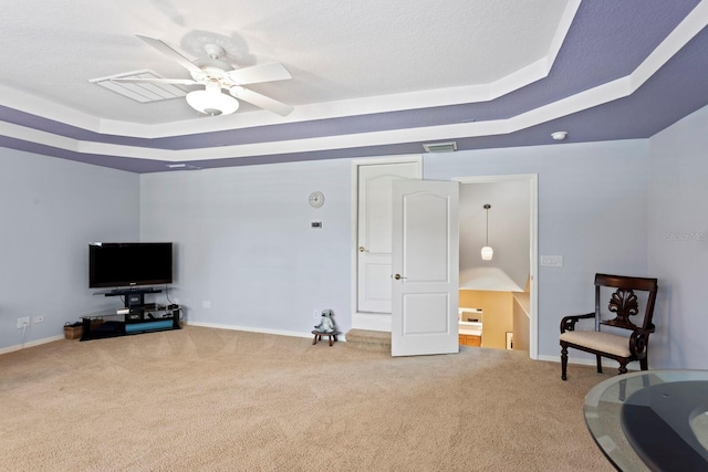 sitting room with a ceiling fan, a raised ceiling, carpet flooring, and visible vents