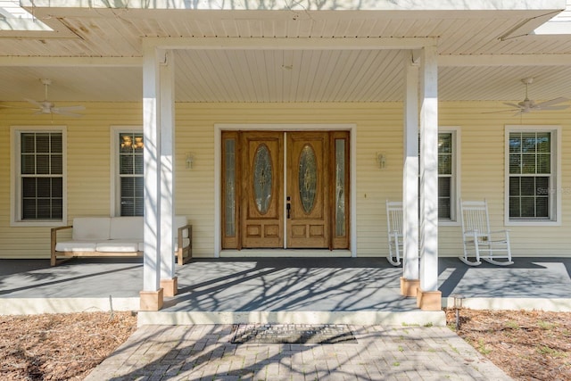 doorway to property featuring a porch and a ceiling fan