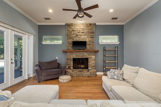 living room with visible vents, a fireplace, ornamental molding, and wood finished floors