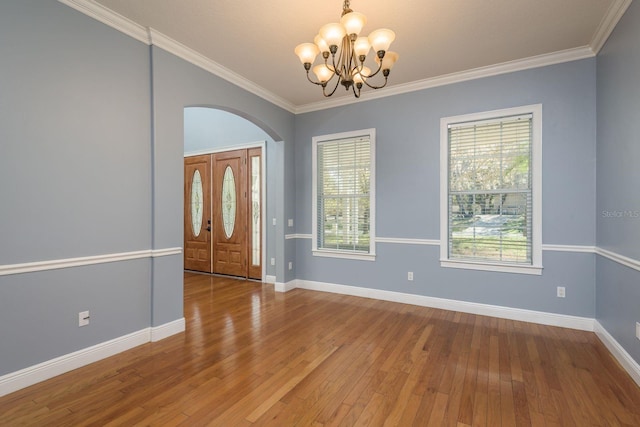 foyer with ornamental molding, baseboards, and hardwood / wood-style floors