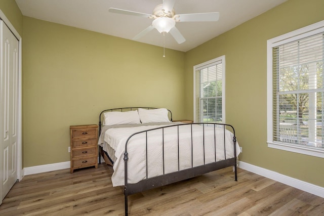 bedroom featuring a ceiling fan, baseboards, and wood finished floors