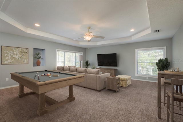 game room with a tray ceiling, carpet, and visible vents