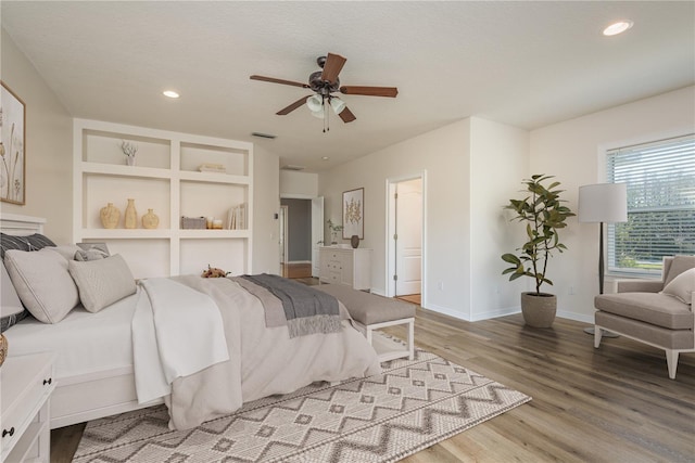 bedroom featuring baseboards, wood finished floors, visible vents, and recessed lighting