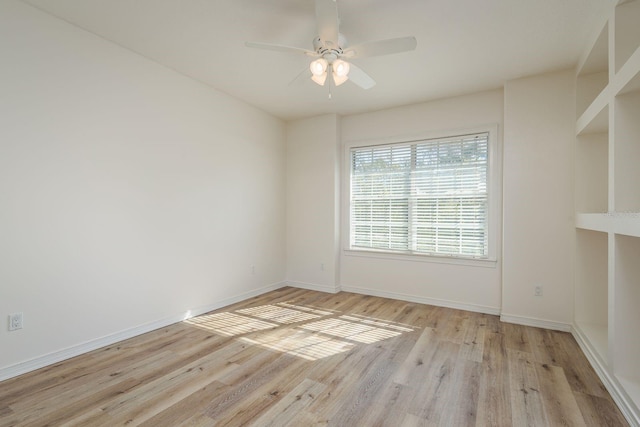 spare room featuring light wood-type flooring, ceiling fan, and baseboards