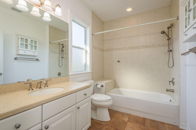 bathroom featuring toilet, vanity, visible vents, and shower / bathing tub combination