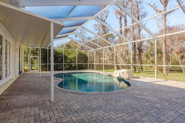 outdoor pool featuring a patio and glass enclosure