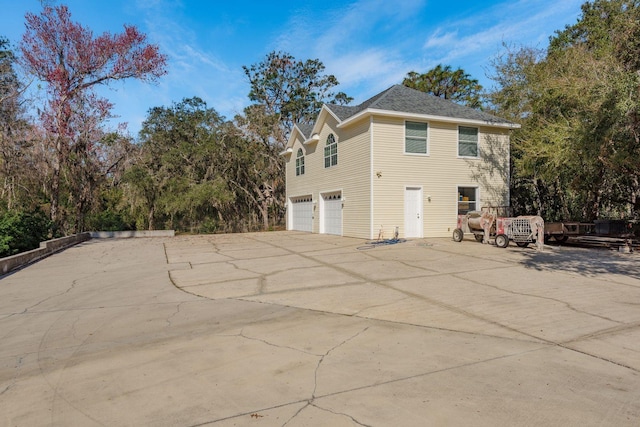 view of side of home with a garage and concrete driveway