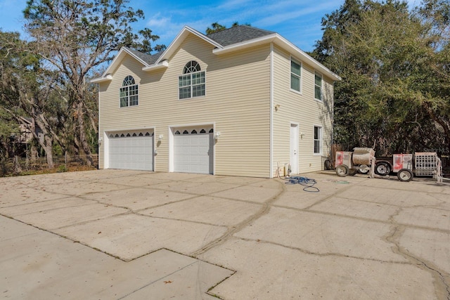 view of side of home featuring driveway and a garage