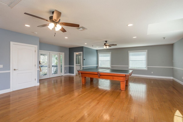 game room featuring baseboards, plenty of natural light, and light wood-style floors